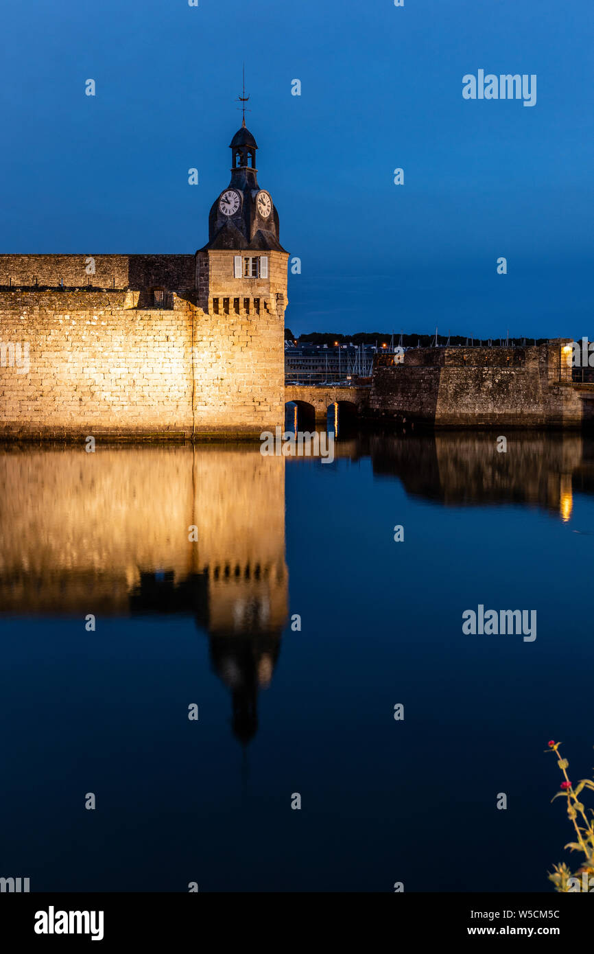 Night Time, the clock tower and short causeway entrance to the old fortified town of Concarneau Stock Photo