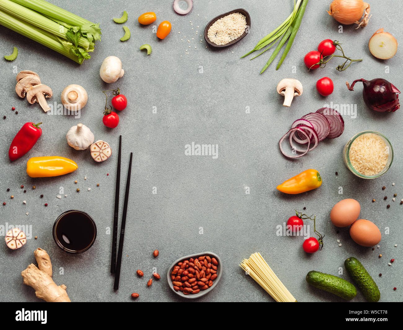 Asian food ingredients with copy space. Various of Chinese cooking ingredients and chopsticks on gray stone background. Asian food concept. Copy space for text. Top view or flat lay. Stock Photo