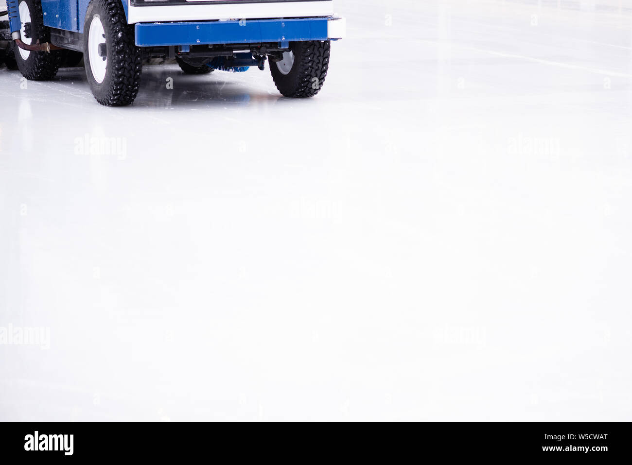 Resurfacing machine cleaning ice of hockey rink. Copy space Stock Photo