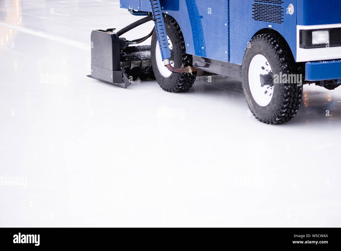 Resurfacing machine cleaning ice of hockey rink. Copy space Stock Photo