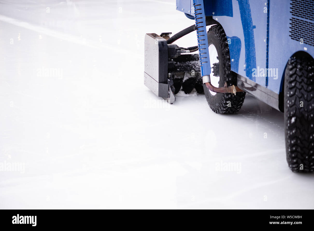 Resurfacing machine cleaning ice of hockey rink. Copy space Stock Photo