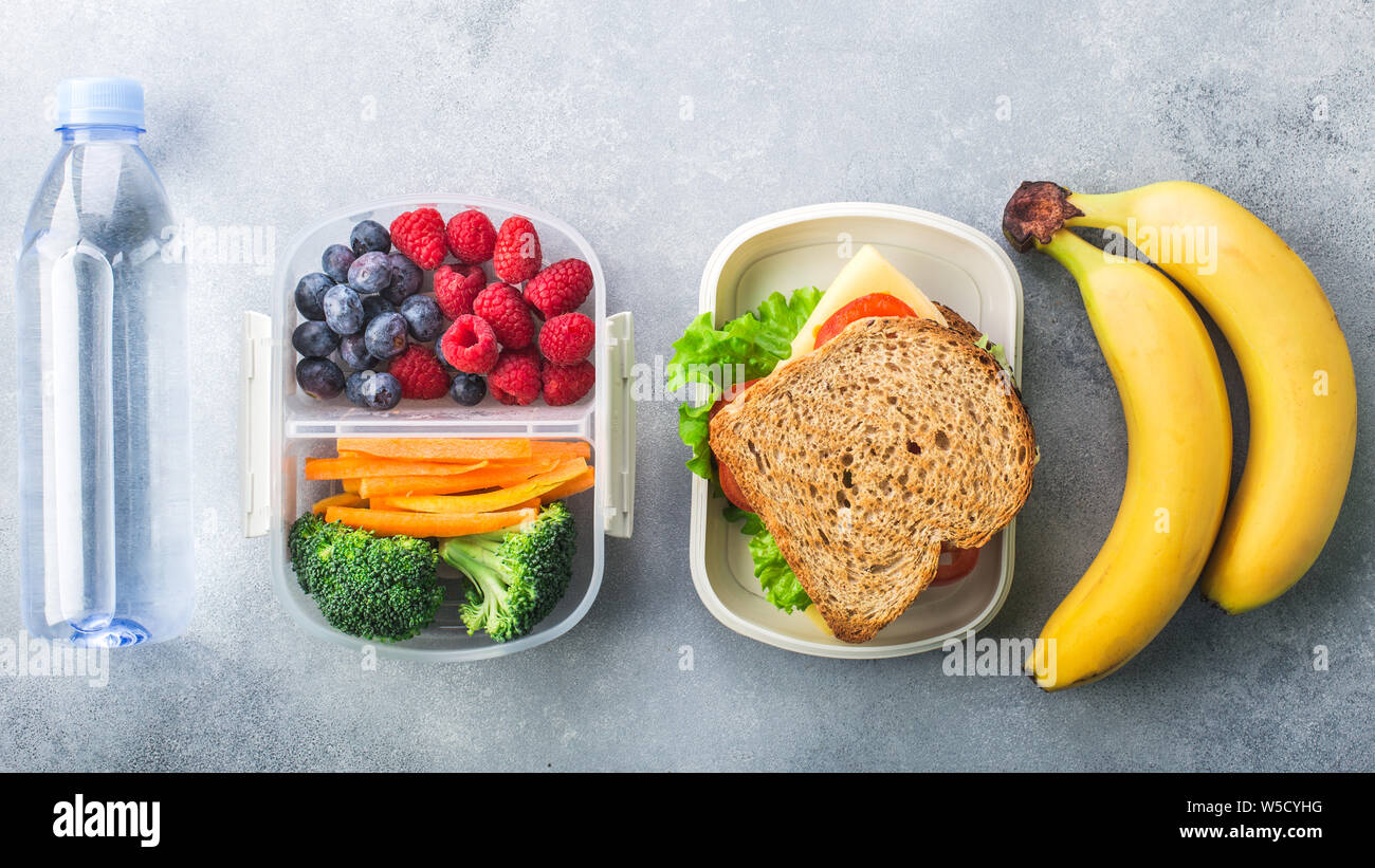 School lunch box with sandwich vegetables water almonds and fruits on