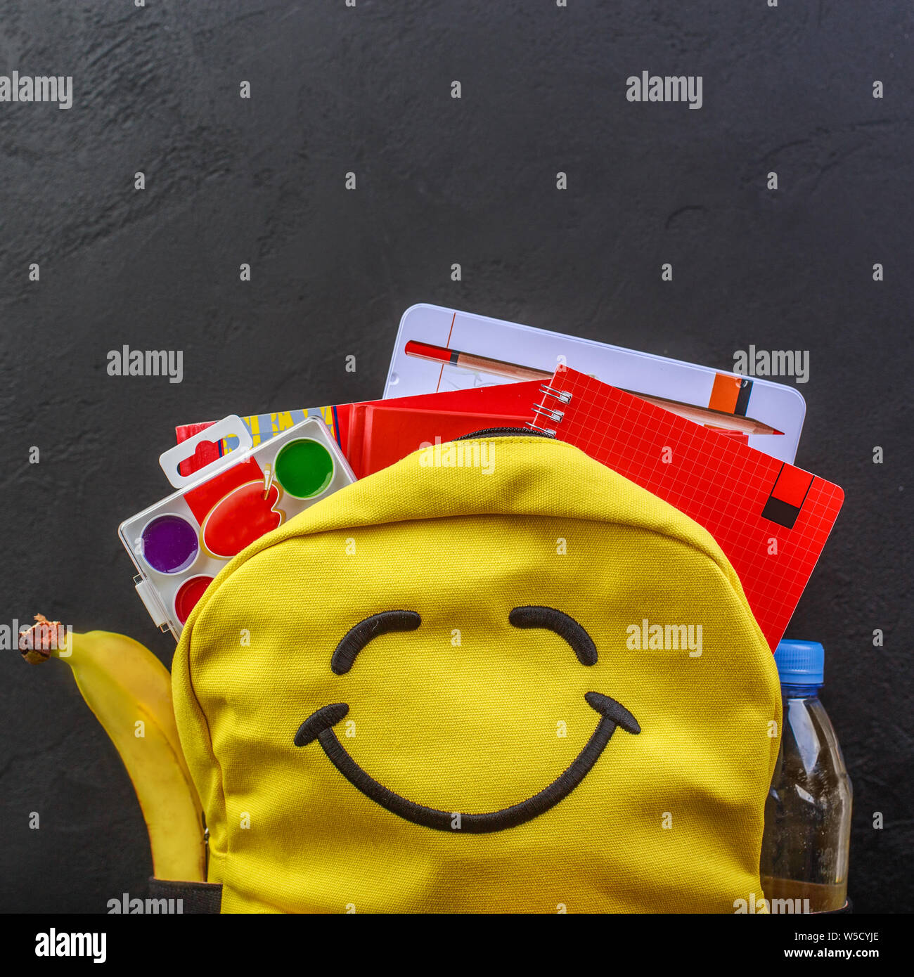 Yellow school backpack with accessories on black background Stock Photo