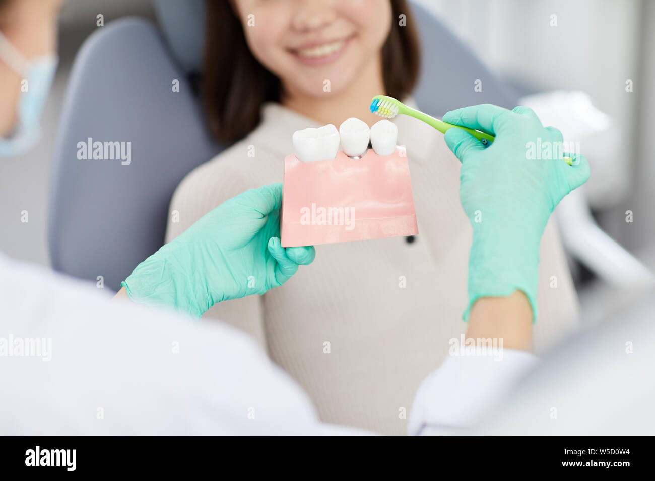 Midsection closeup of unrecognizable female dentist explaining tooth