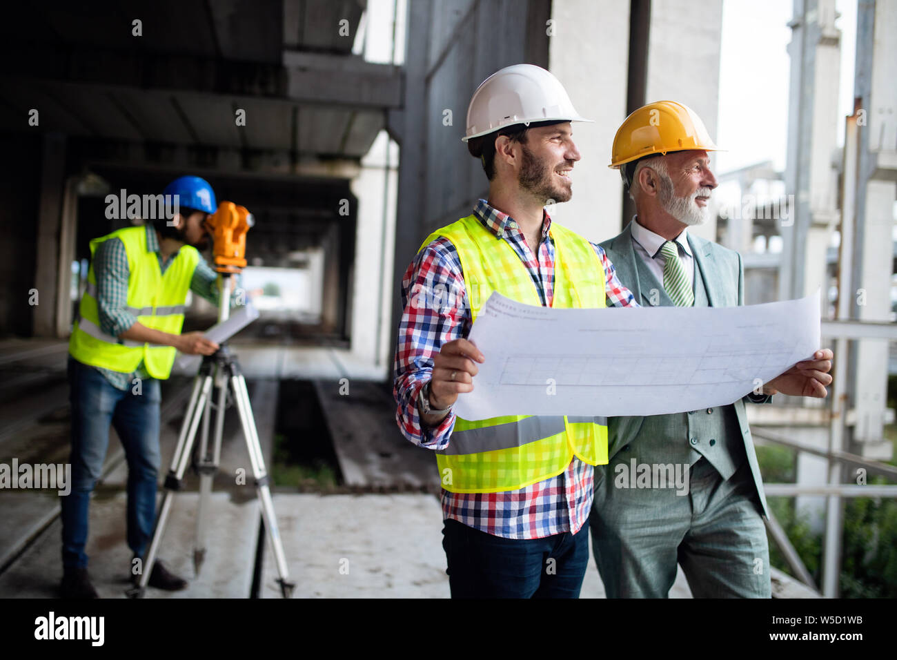 Engineer and construction site manager dealing with blueprints and ...