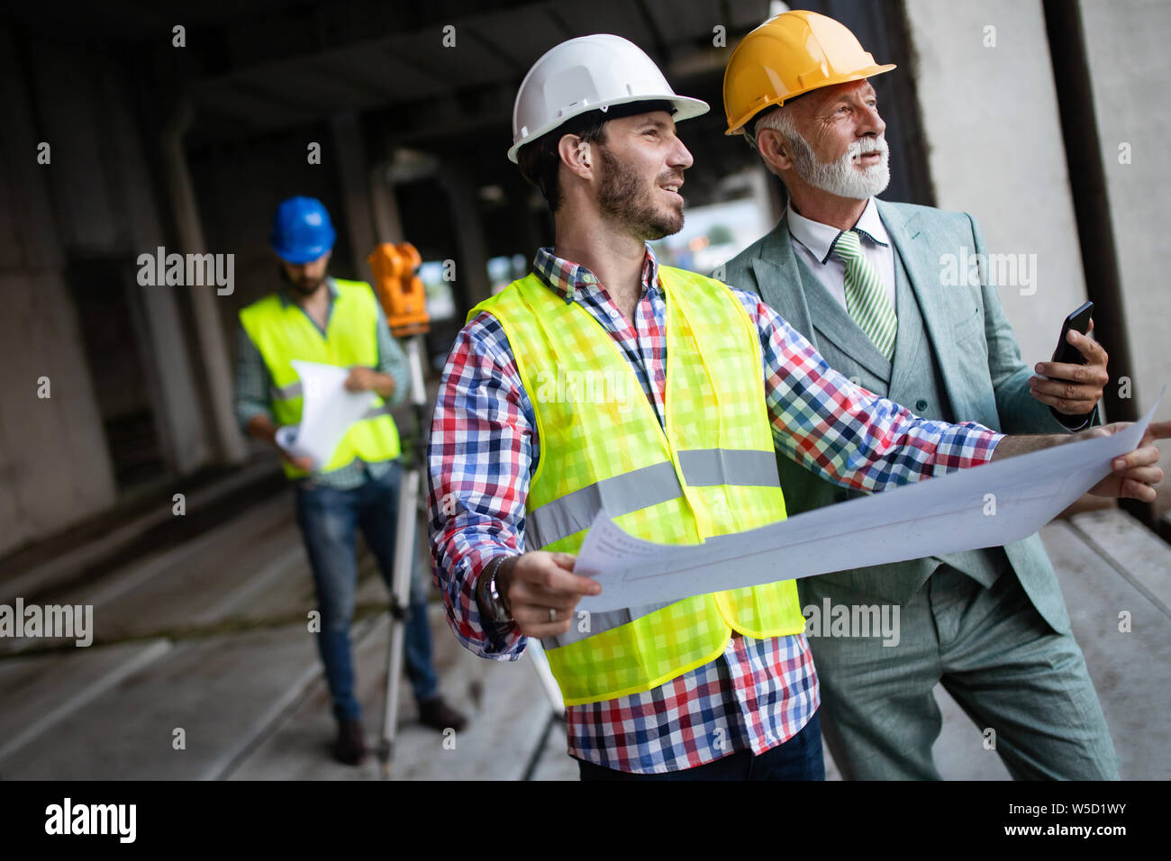 Engineer and construction site manager dealing with blueprints and plans Stock Photo