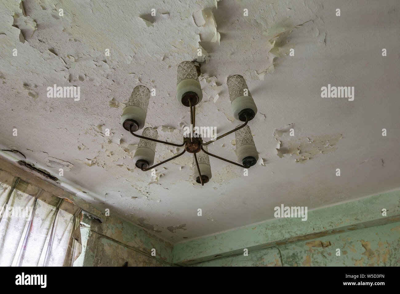 A chandelier in the ceiling of the abandoned house Stock Photo