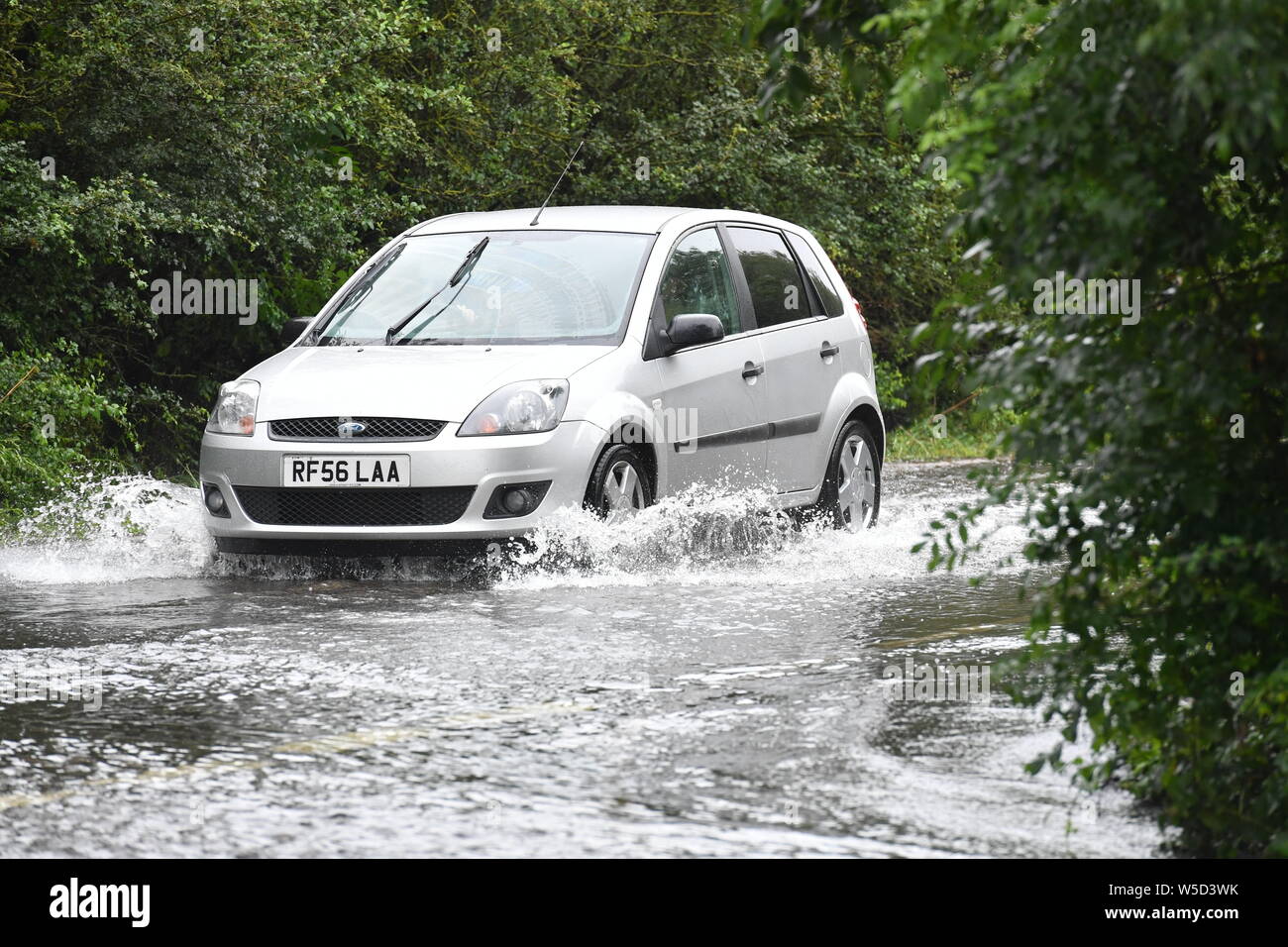 Cars make their way through standing water on Mountsorrel Lane in Loughborough after heavy rain fell throughout the country. Stock Photo