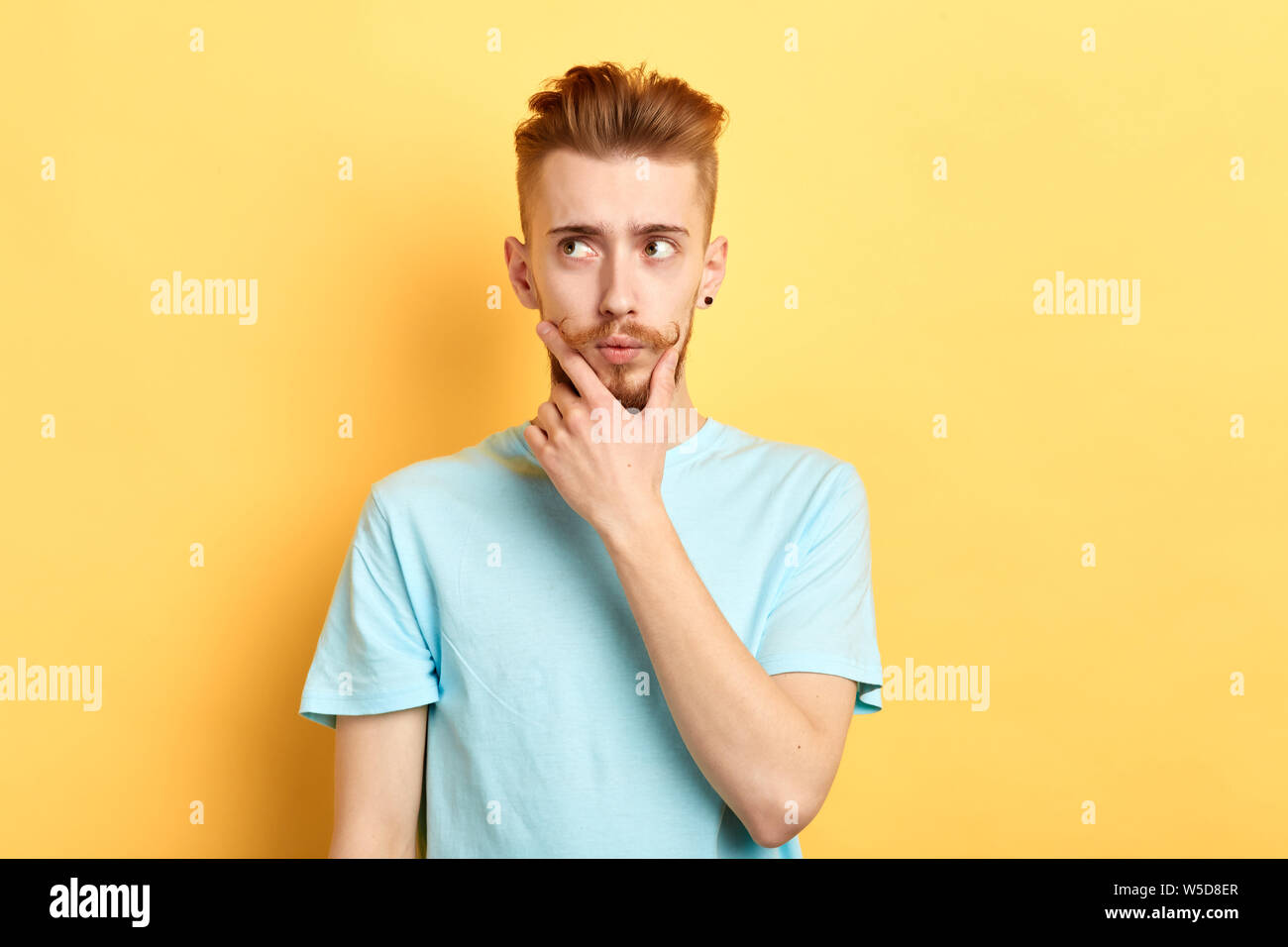 thoughtful pensive serious man who looks aside touching his chin and making up a plan, thinking about the pluses and minuses of the offer isolated on Stock Photo