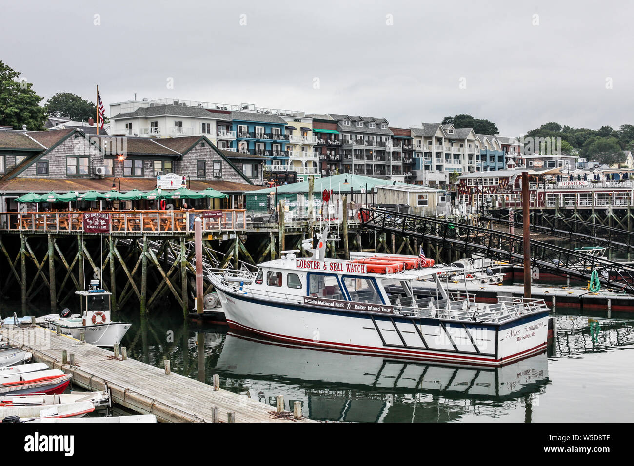 BAR HARBOR, MAINE - JULY 9, 2013: Seafood restaurant with docking attraction boat and hotel view from parking lot near downtown. Stock Photo