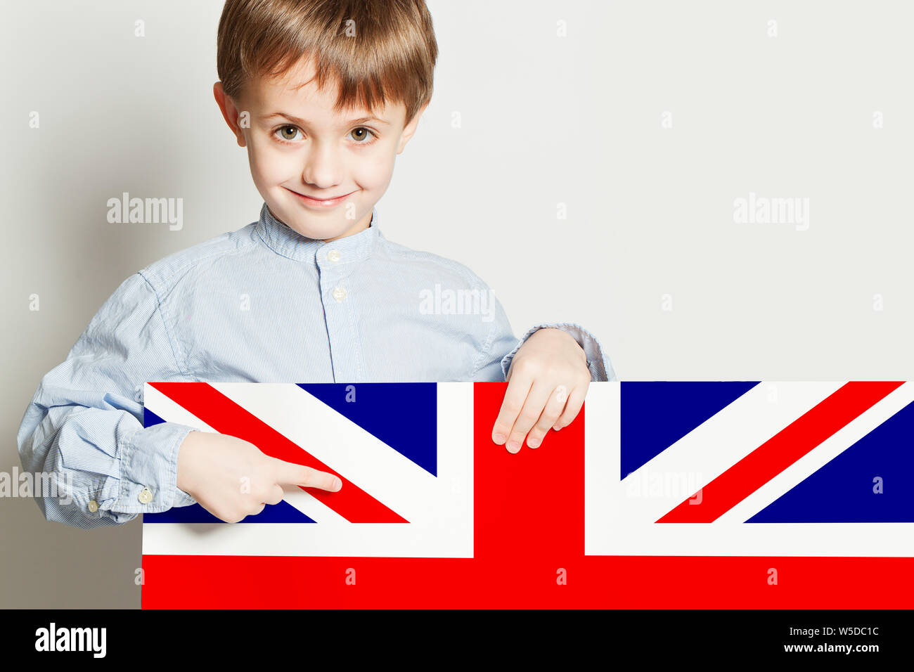 Happy Child Boy Holding The Uk Flag Banner On White Empty