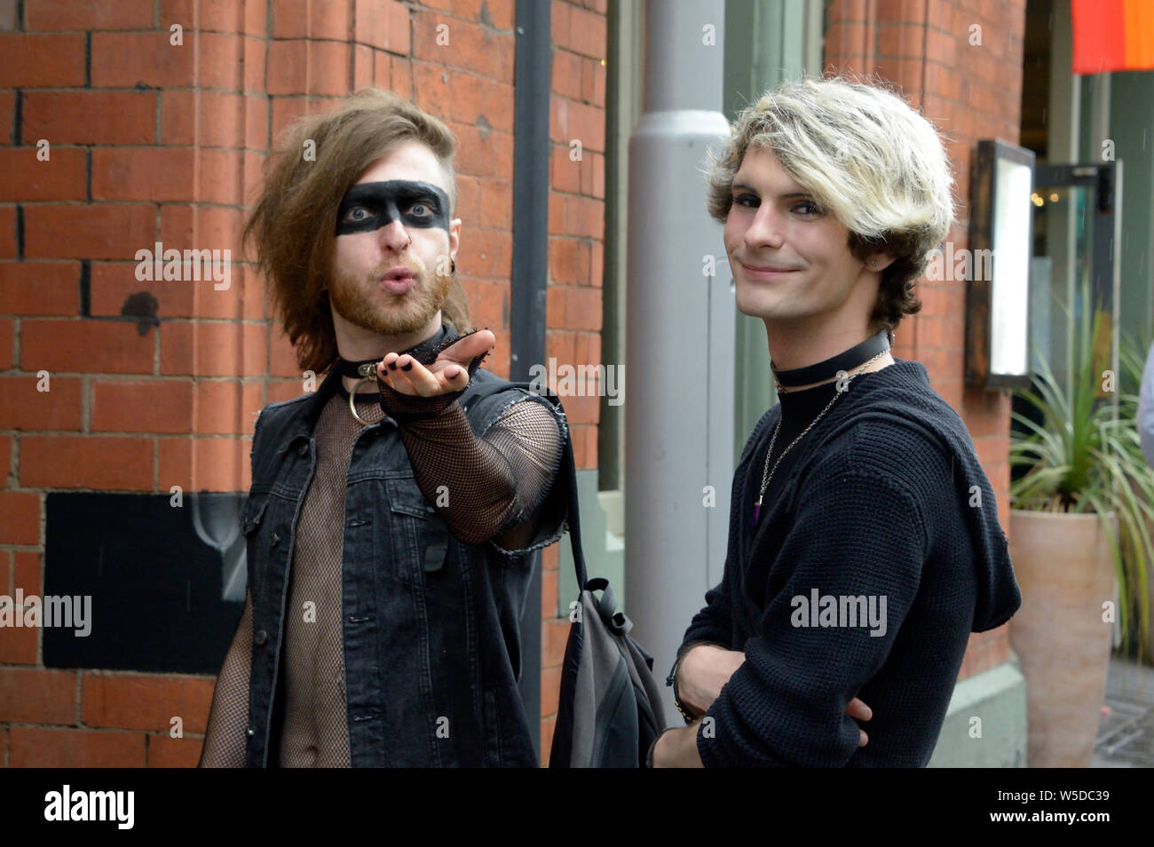 Two guys, in black, with unusual hair styles, & eye make up. Stock Photo