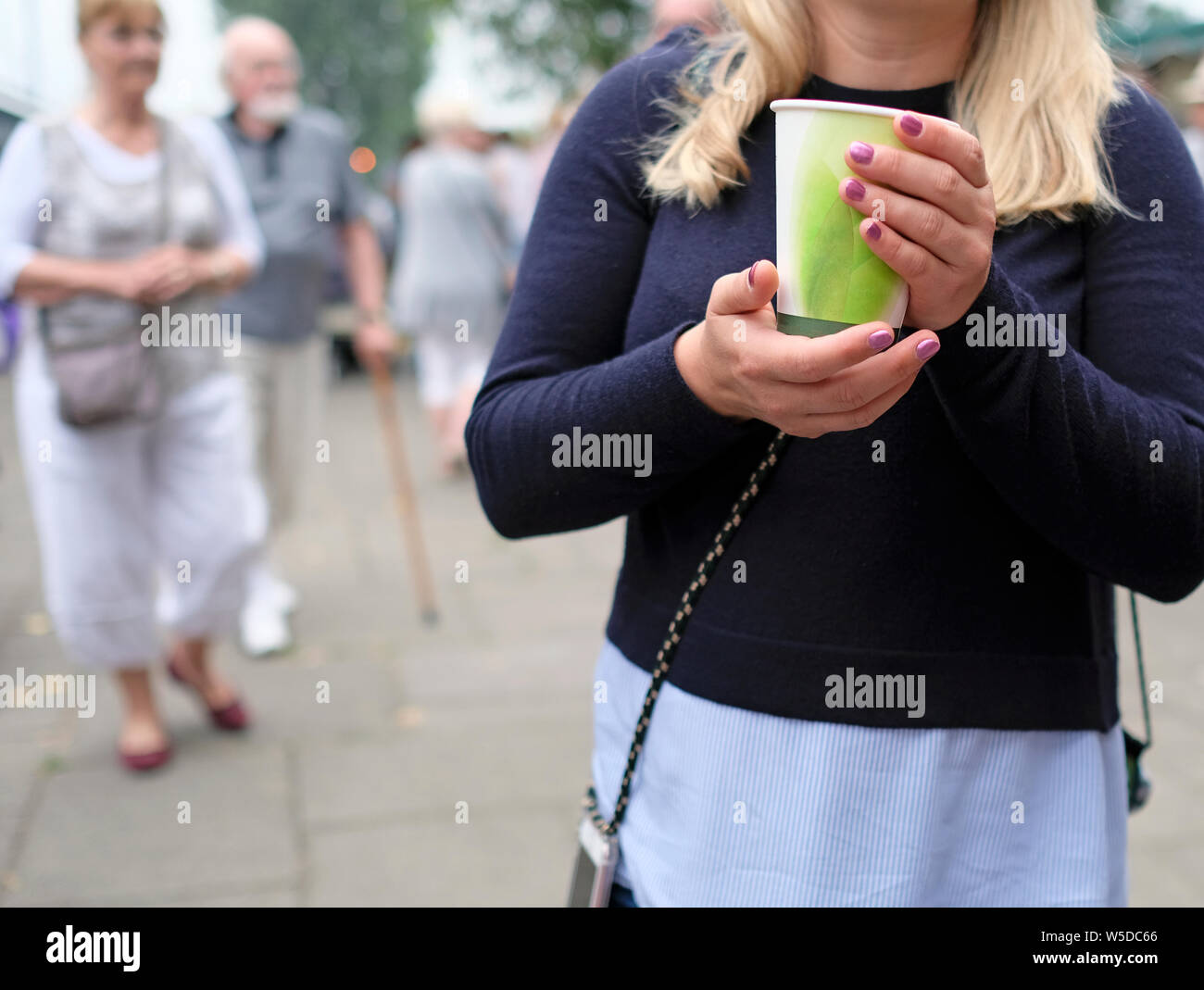 Girl holding a paper cup of coffee Stock Photo