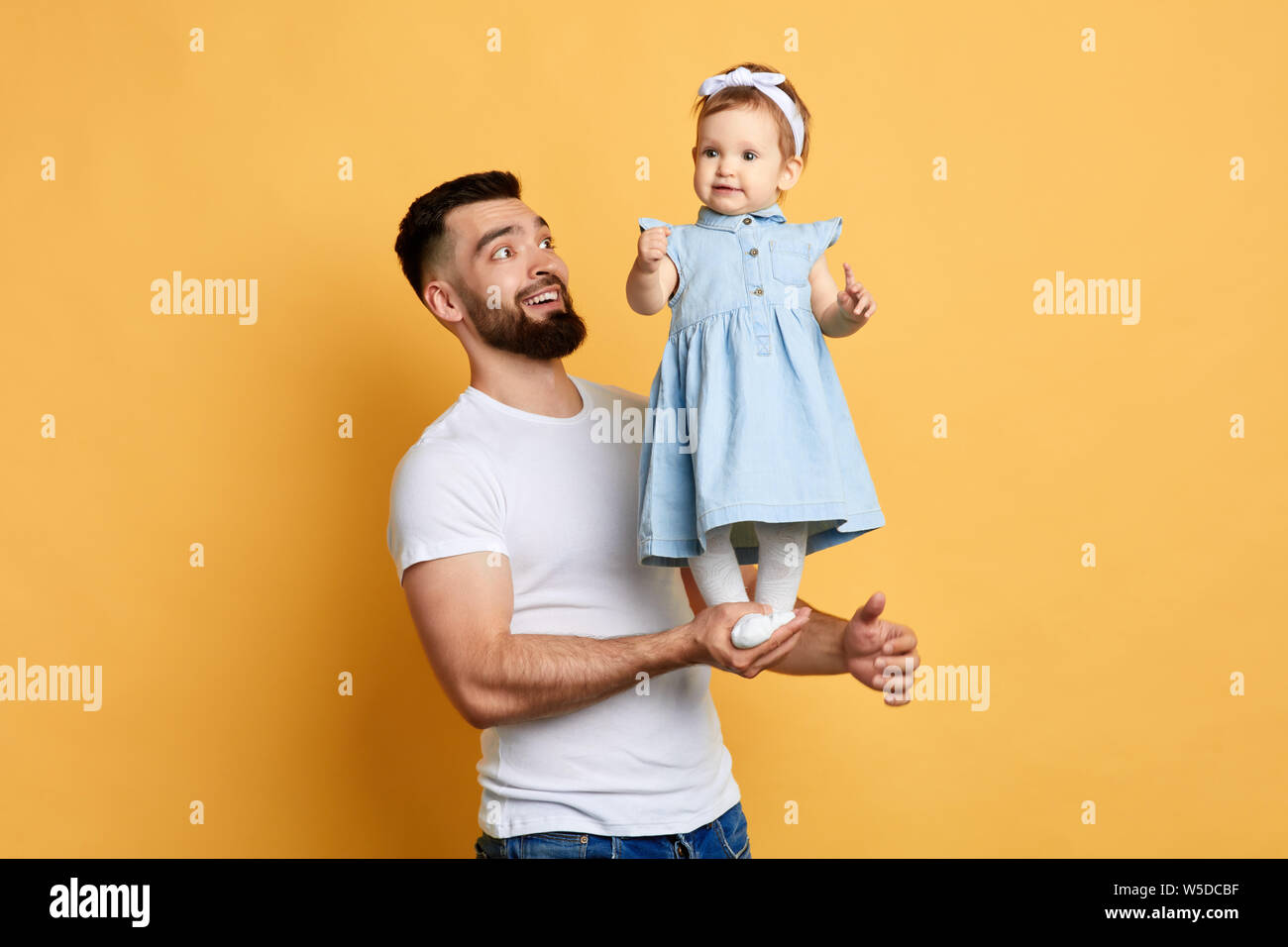 Happy unforgettable moments, excited handsome man rejoicing at his daughter's achievment. daddy teaches his daughter to stand, doing exercises. happy Stock Photo