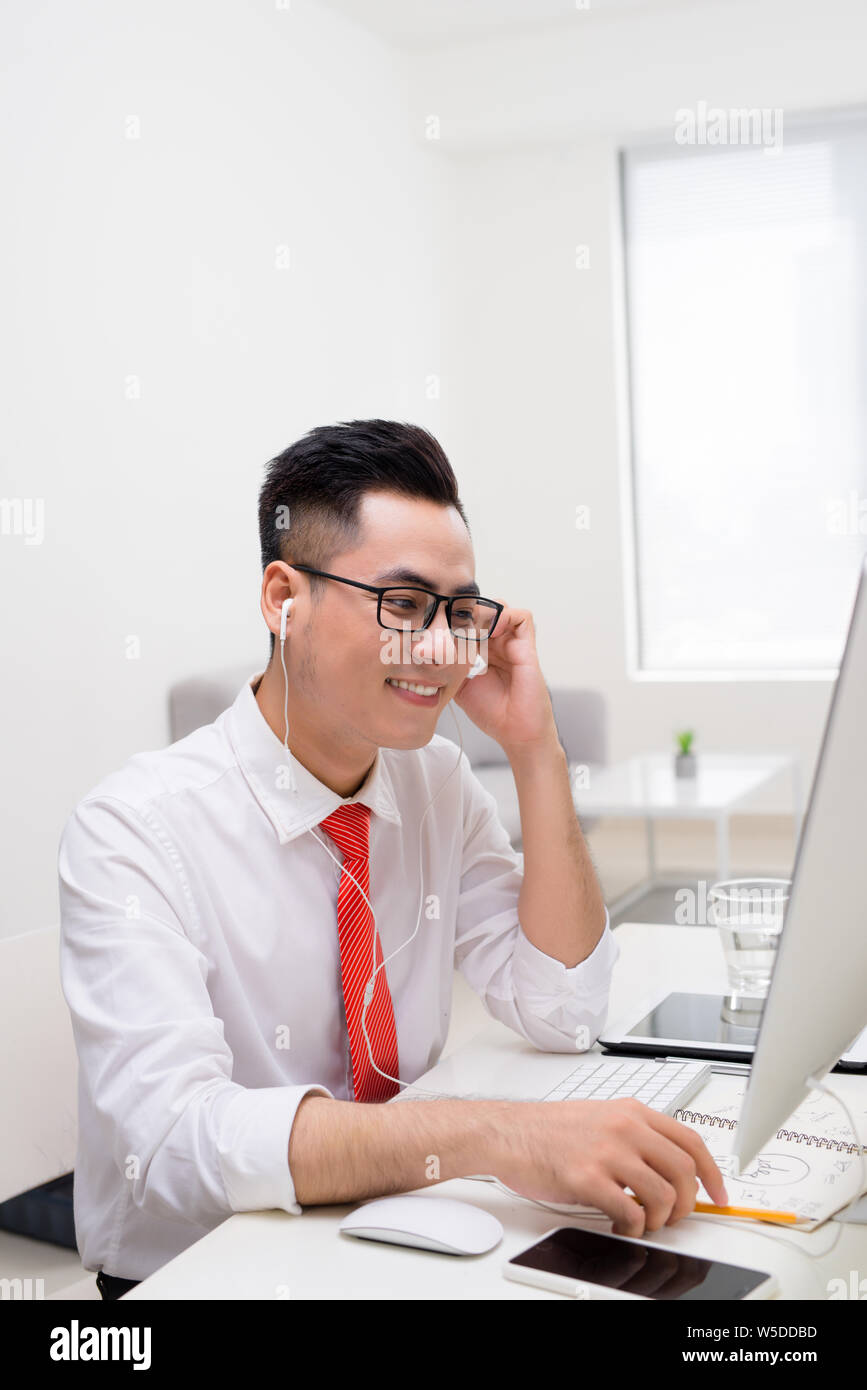 Profile view of a handsome young man doing some meditation exercises while working at the office Stock Photo