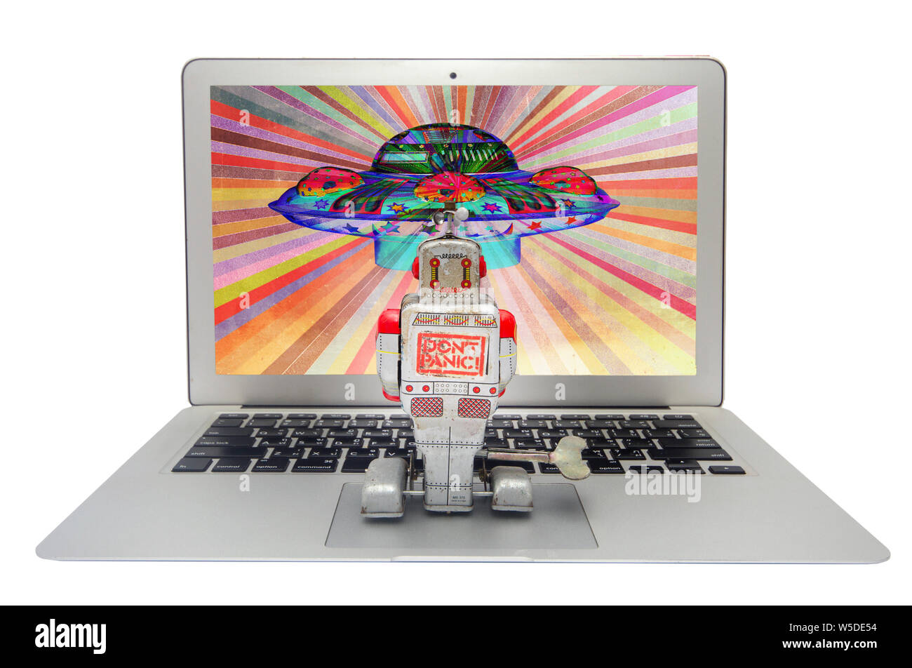 retro tin robot watches a film on his laptop Stock Photo