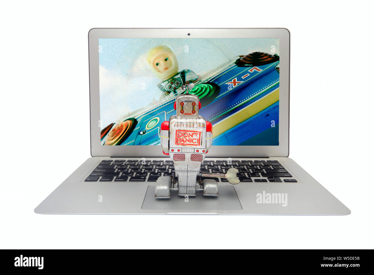 retro tin robot watches a si fi  film on his laptop Stock Photo