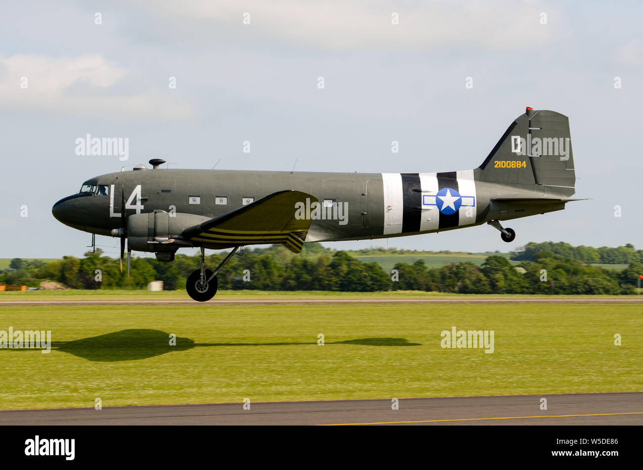 Douglas C-47 Skytrain military transport plane. Second World War airplane in USAAF D-Day Normandy colours with invasion stripes. Landing Stock Photo