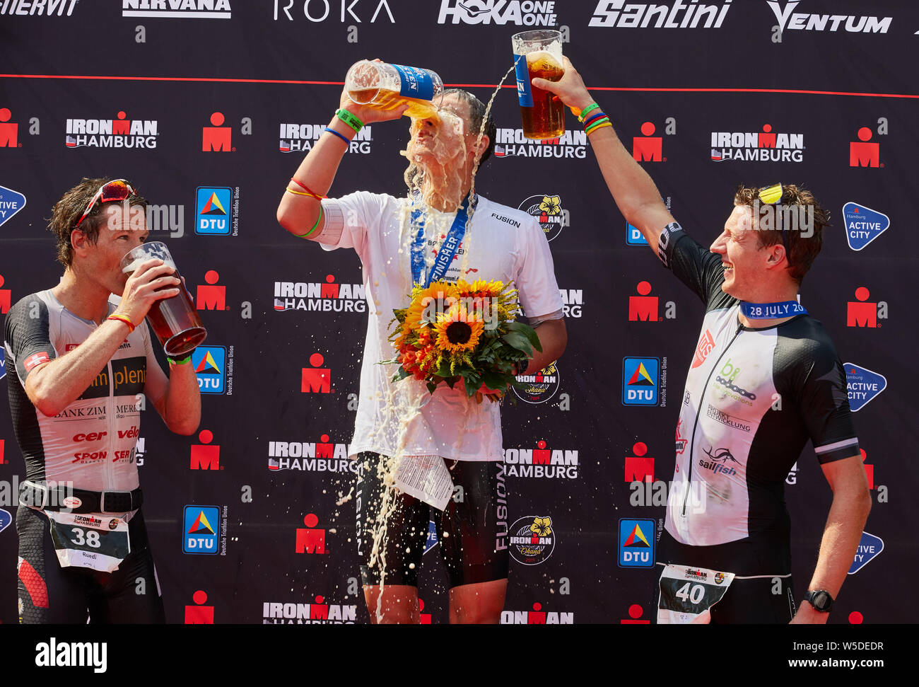 Hamburg, Germany. 28th July, 2019. Triathlon: Ironman World Series/German  Championship, Men: Ruedi Wild (l-r) from Switzerland (2nd place), Kristian  Hogenhaug from Denmark (1st place) and Paul Schuster from Griesheim  (Germany, 3rd place)