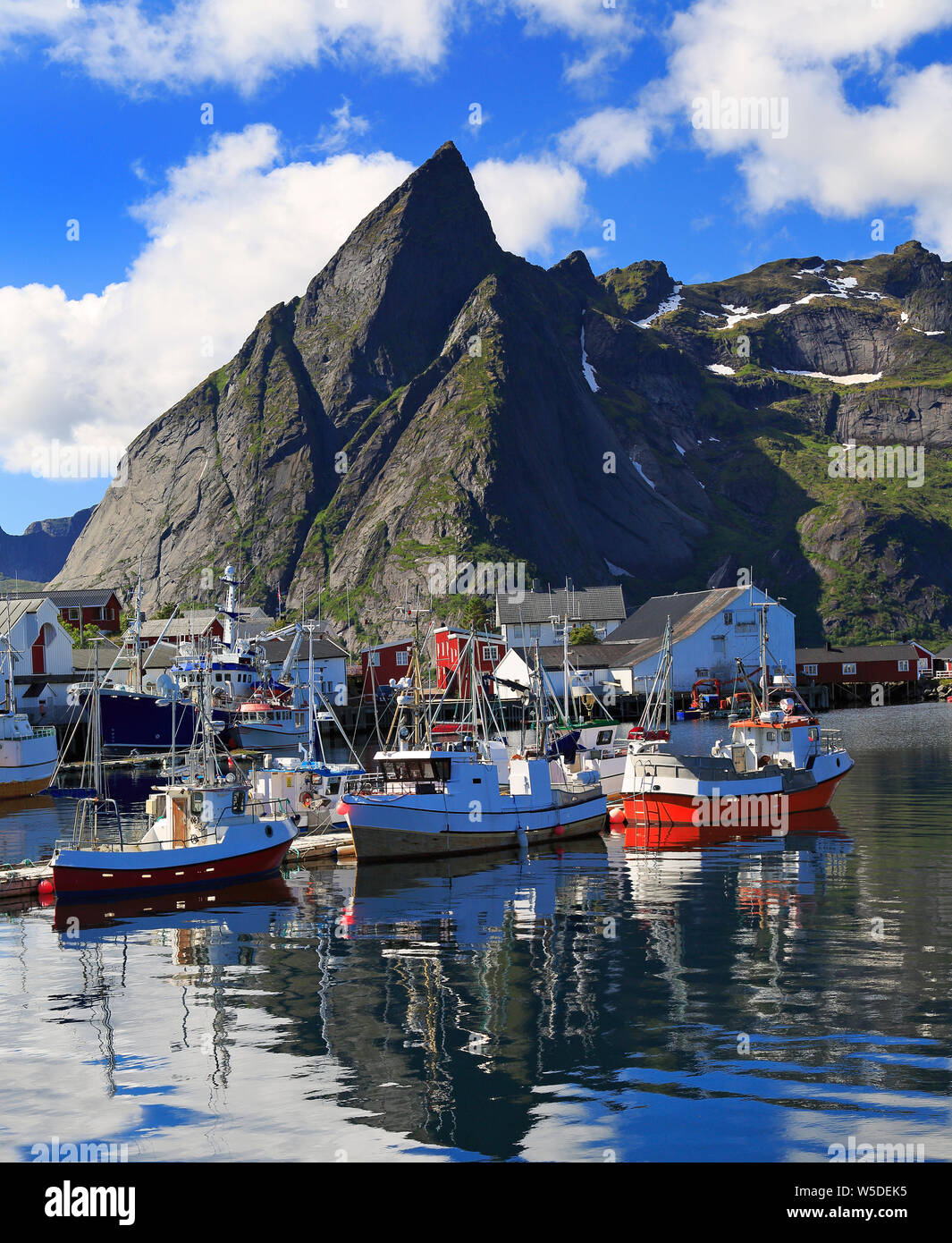 Traditional Norwegian fishing boats in Lofoten Island, Reine area with nice reflections in the ocean fjord Stock Photo