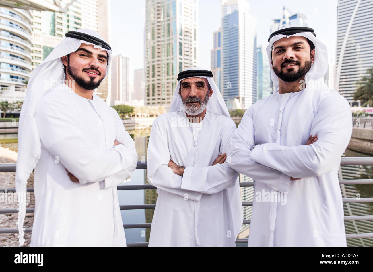 three-business-men-walking-in-dubai-wearing-traditional-emirati-clothes-W5DFW9.jpg