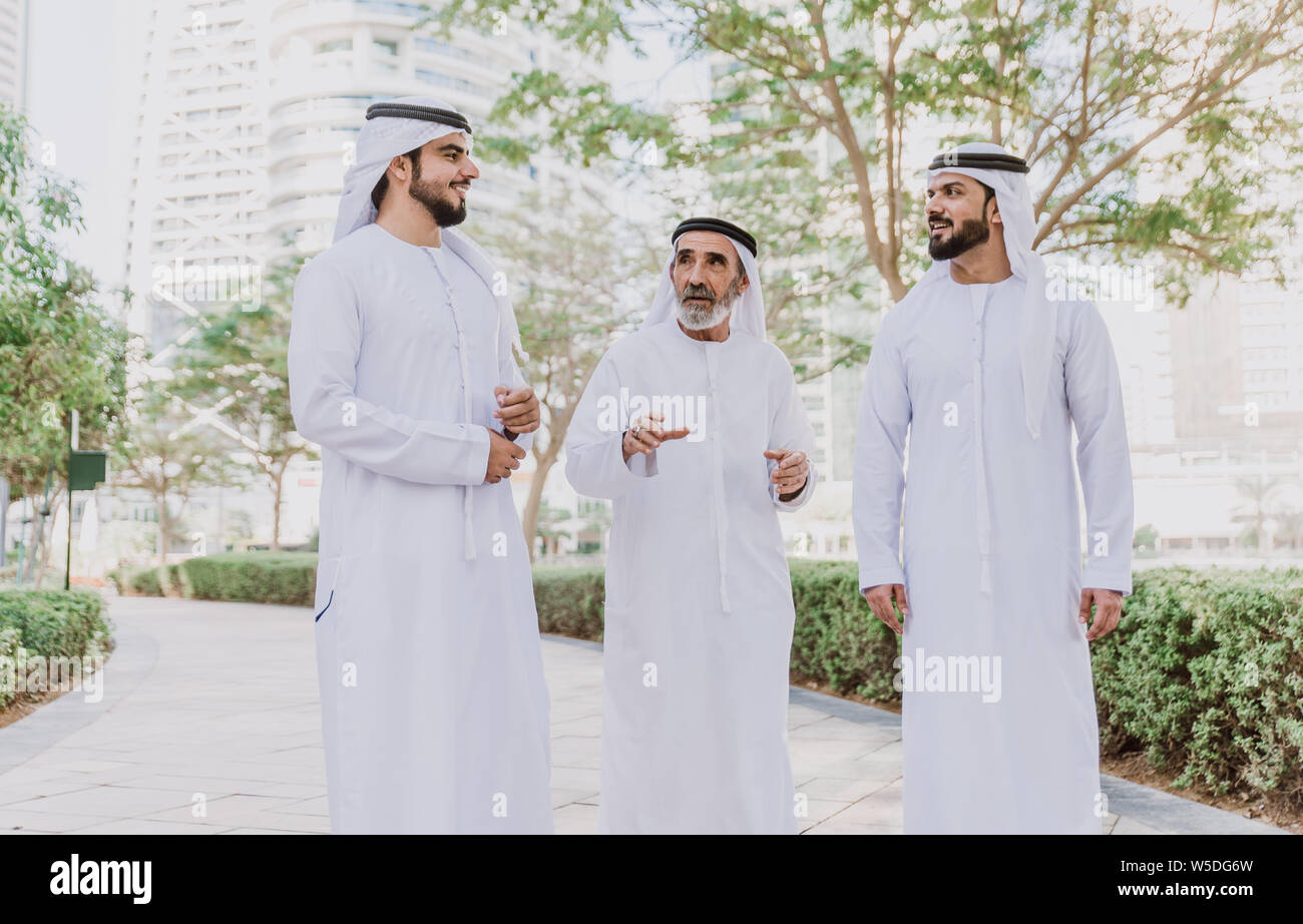 Three business men walking in Dubai wearing traditional emirati clothes  Stock Photo - Alamy
