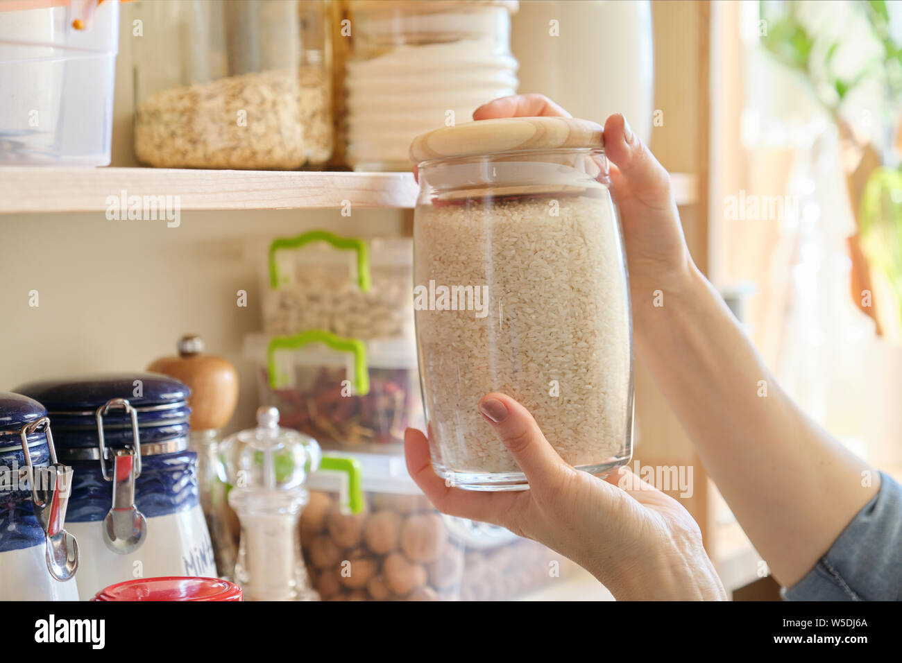 Food products in the kitchen storing ingredients in pantry. Woman