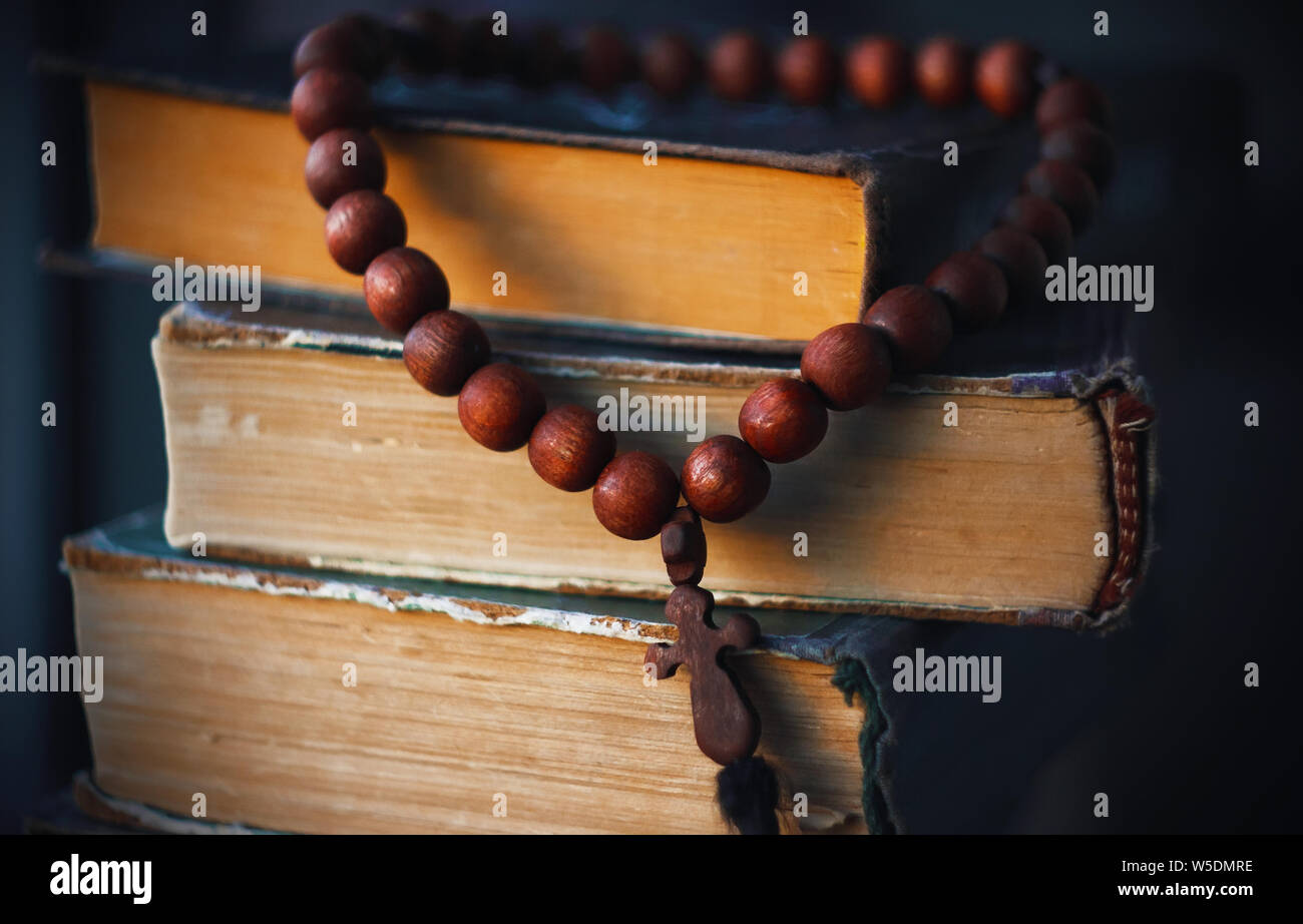 On the old battered Holy Scriptures hang rosaries from beads of red wood, like a Holy relic Stock Photo