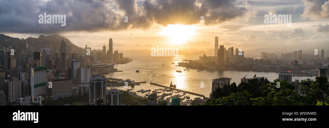 Panoramic landscape or cityscape of Hong Kong island, Victoria harbour, and Kowloon city at sunset, view from Red incense burner summit. Asia travel Stock Photo