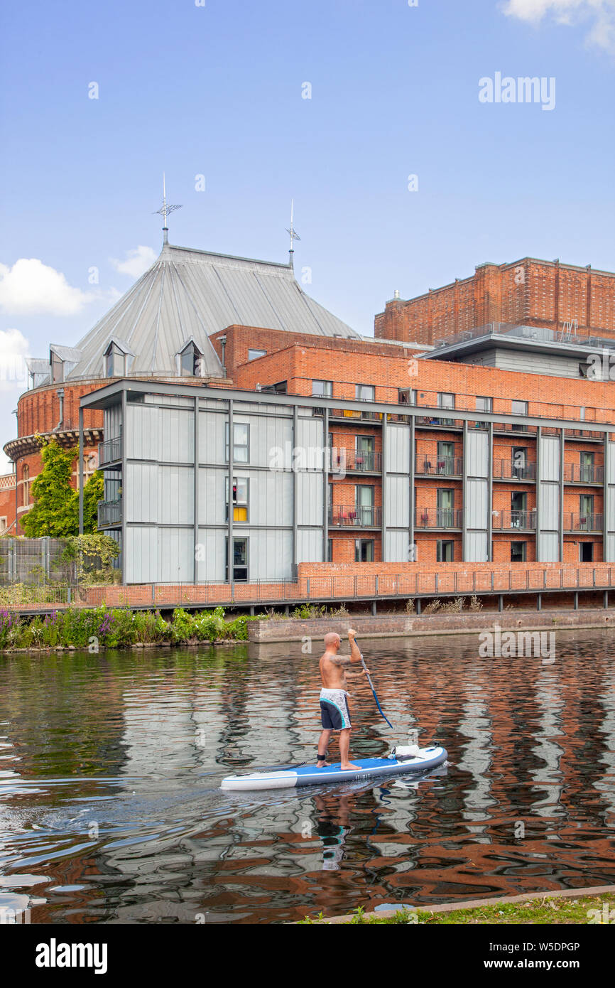 Man stand up paddle boarding on the the river Avon as it passes in