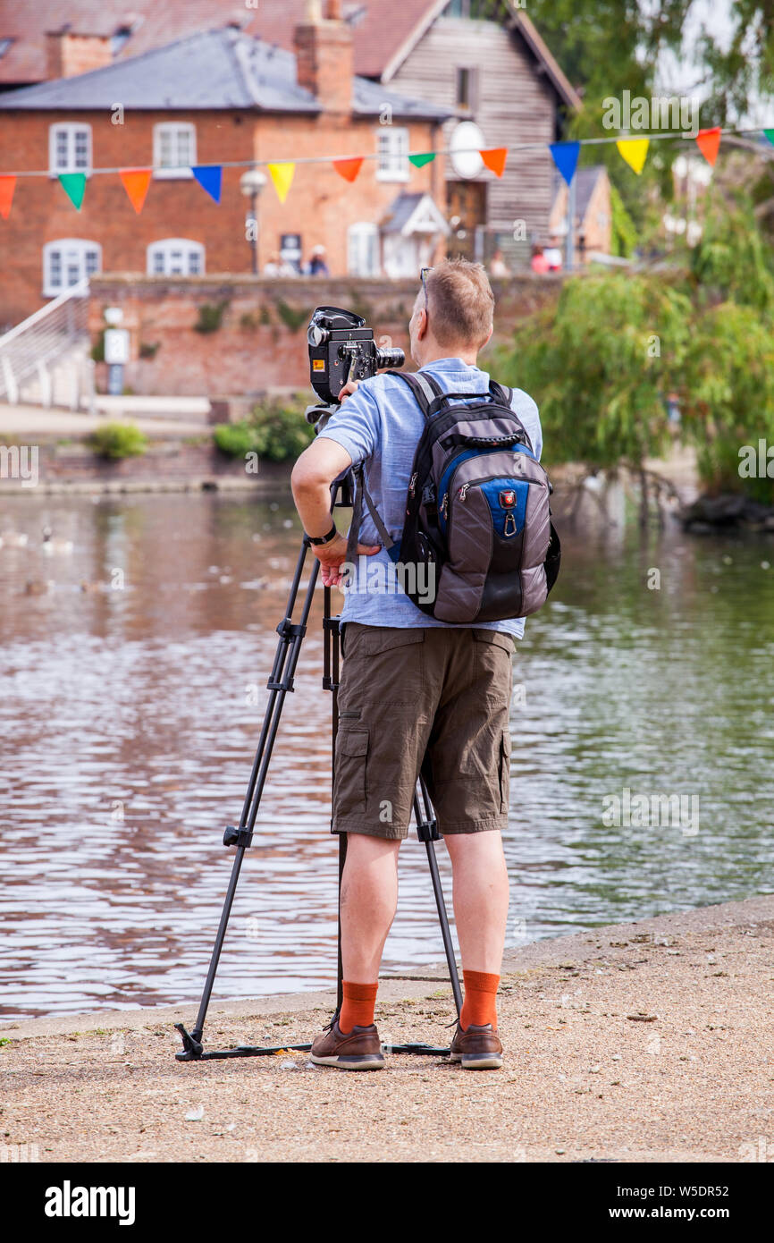 Man using a Switzerland made  Bolex super 16 SBM  film cine camera on the banks of the river Avon in Statford upon Avon Warwickshire England Stock Photo