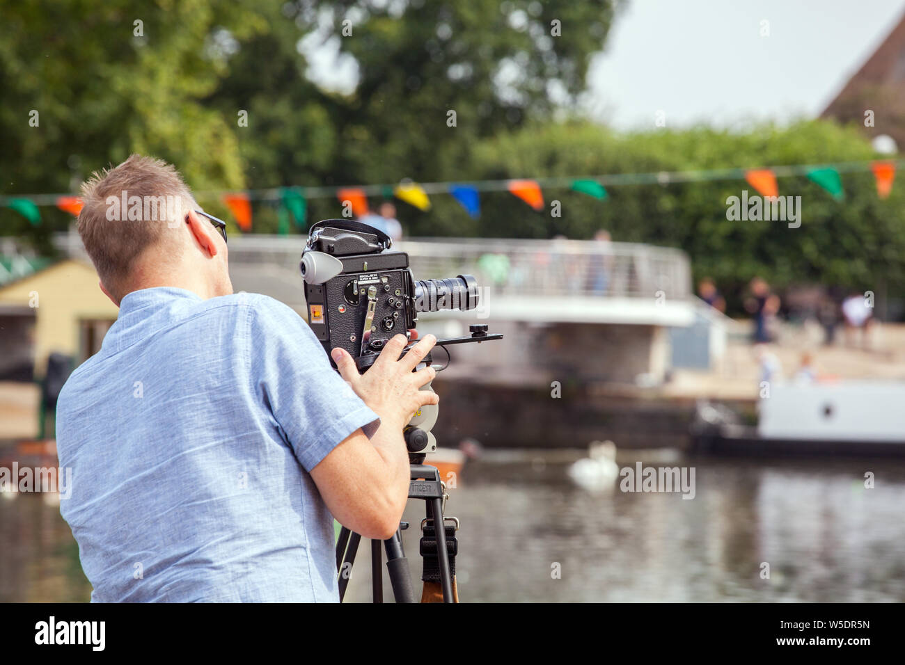 Man using a Switzerland made  Bolex super 16 SBM  film cine camera on the banks of the river Avon in Statford upon Avon Warwickshire England Stock Photo