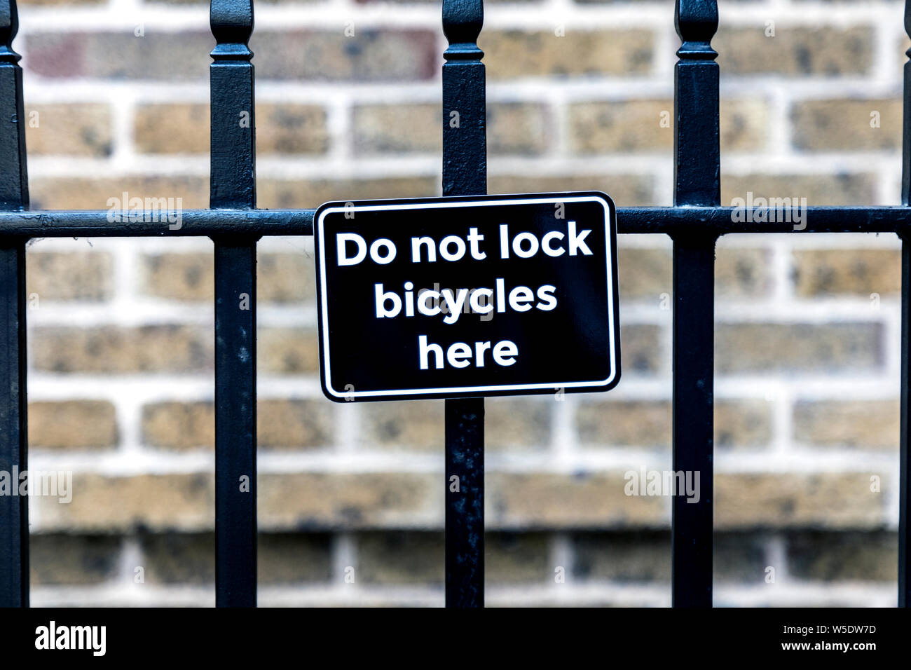 'Do not lock bicycles here' sign attached to an iron fence, Soho, London, UK Stock Photo
