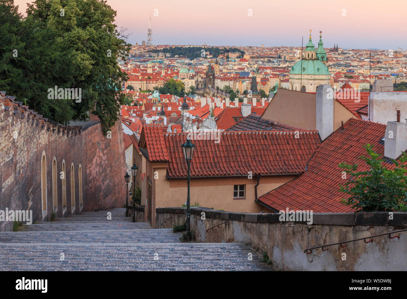 City view from the Prague district Lesser Town. Steps from the Prague Castle down to the old town. Historical masonry along the castle overlooking old Stock Photo