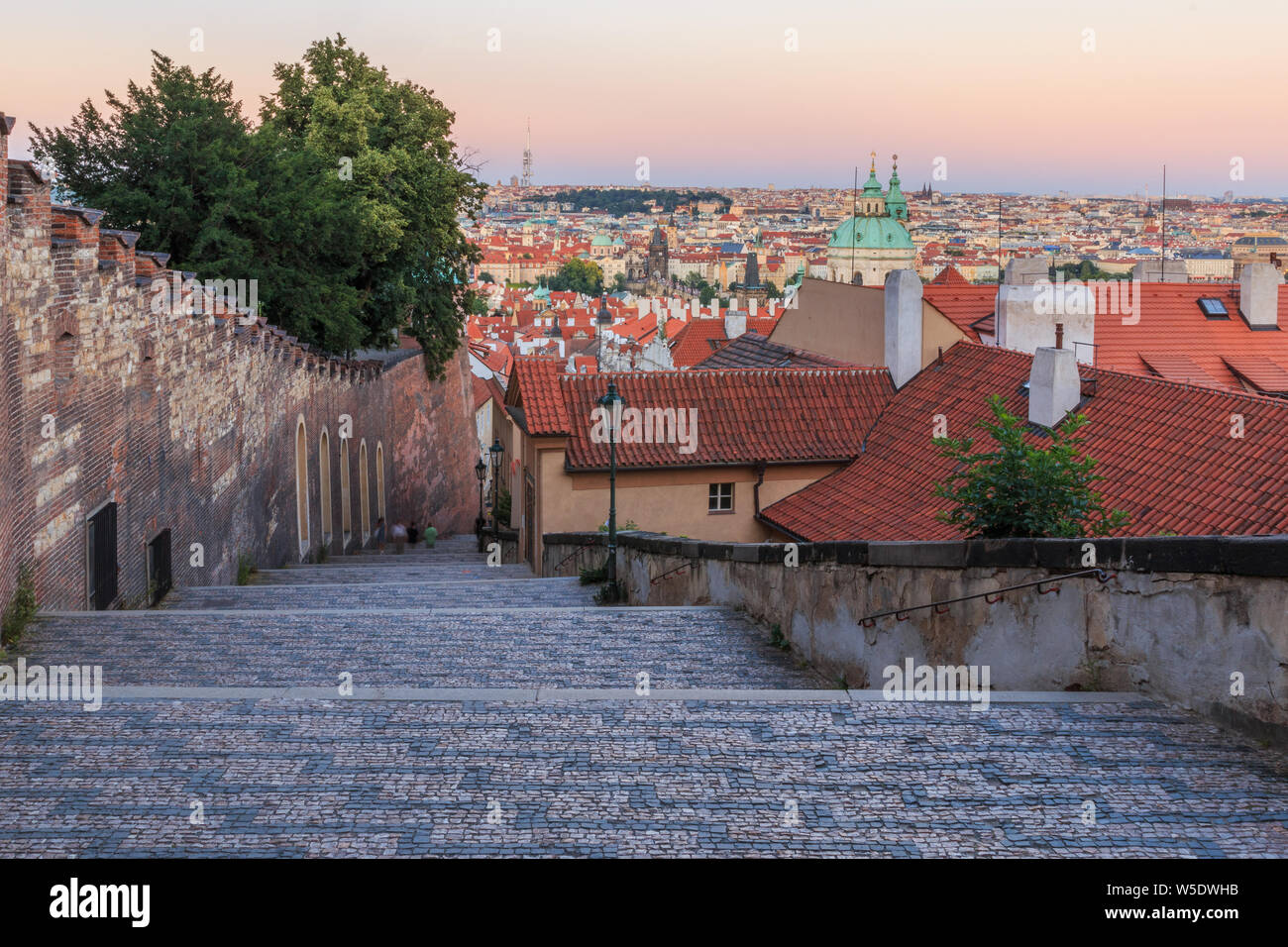 View over old town Prague in the evening. Roofs of the district Lesser Town with stairs of the Prague Castle with alley and trees. Historic buildings Stock Photo