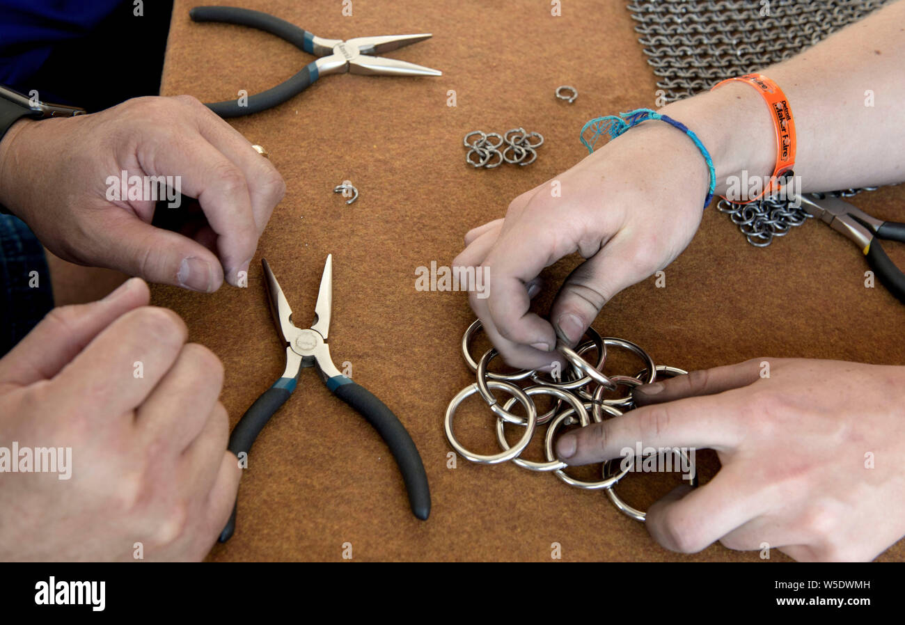 Dearborn, Michigan, USA. 28th July, 2019. Instruction in the art of fabricating chain mail during the 10th Annual Maker Faire Detroit at the Henry Ford Museum of American Innovation. Maker Faire is a gathering of tech enthusiasts, tinkerers, engineers and science club members who gather to show and share knowledge about what they've made. Credit: Brian Cahn/ZUMA Wire/Alamy Live News Stock Photo