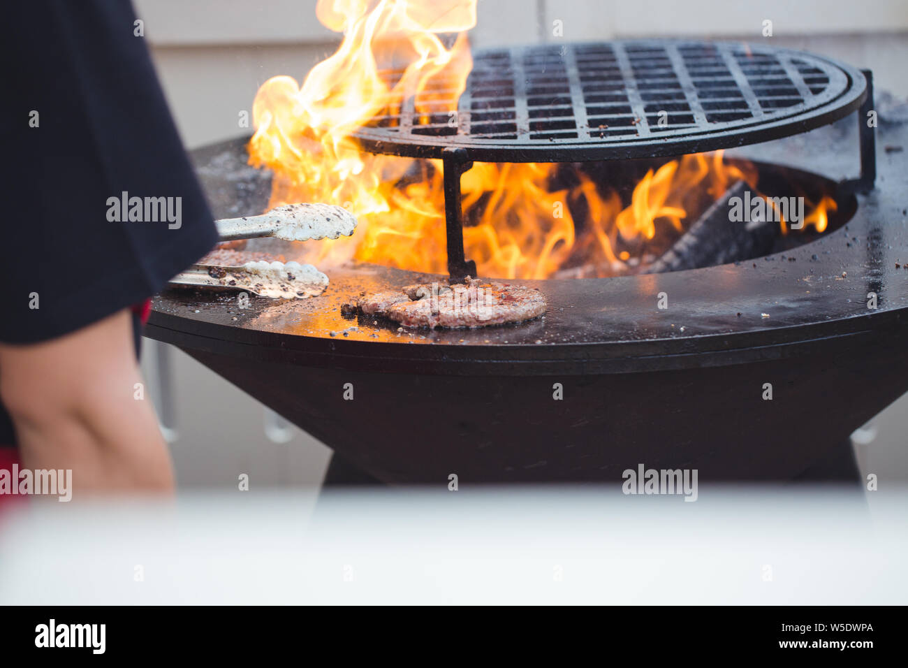 Preparing juicy burger cutlets on grill Stock Photo