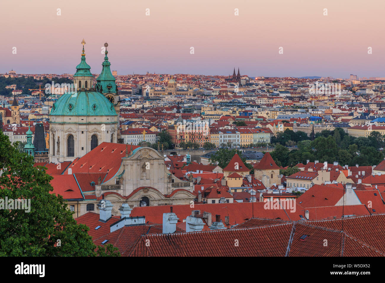 View over Prague from the district Lesser Town with stairs from the Prague Castle with alley, historical buildings and trees in the evening. View over Stock Photo