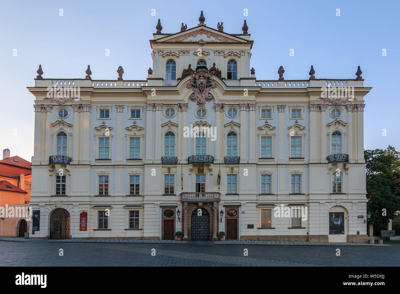 Archbishop Palace near the entrance to the Prague Castle on Hradschin Square. Historic white building with decorations in the evening sun Stock Photo