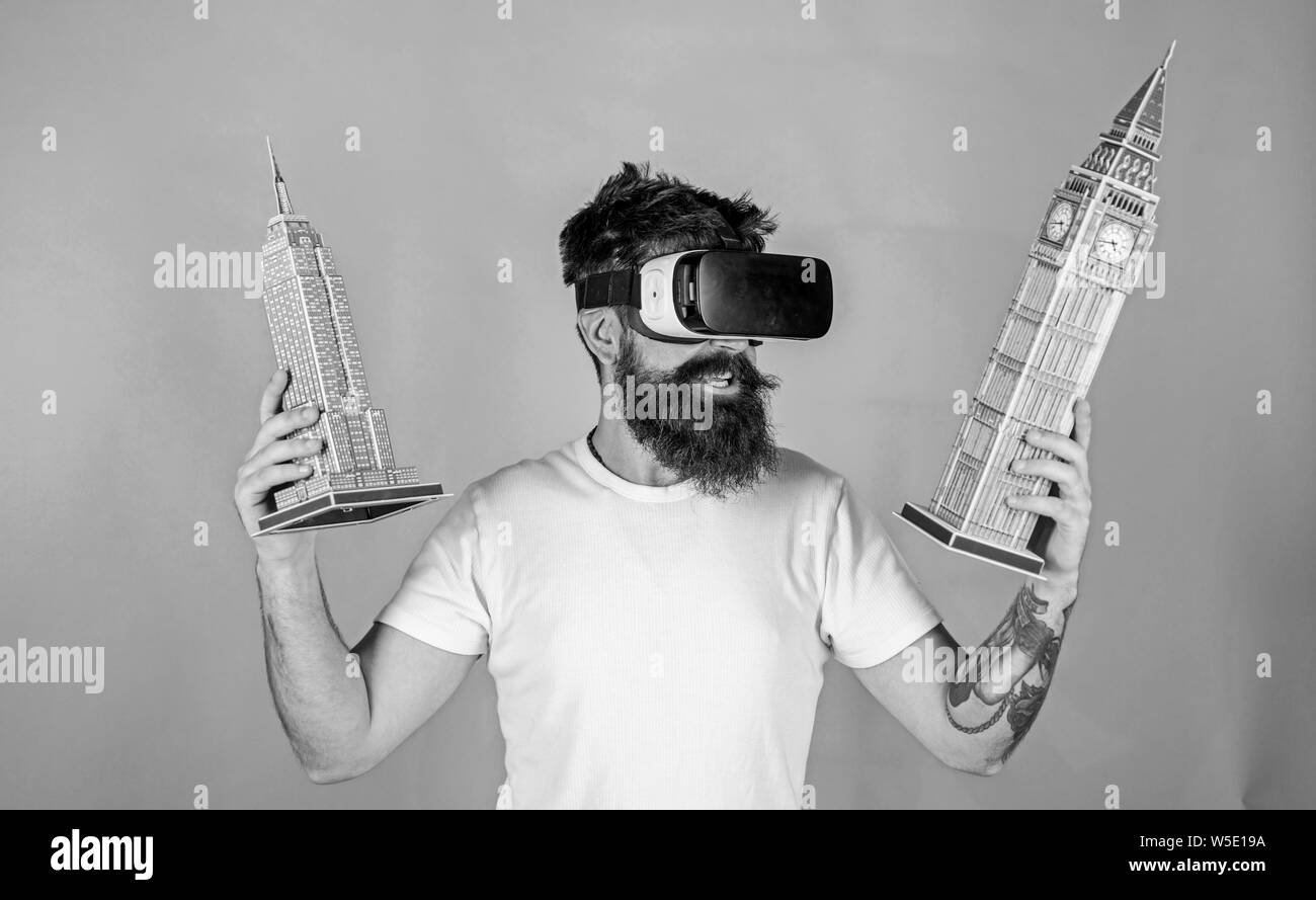 Man with hipster beard in VR glasses holding 3D models of Big Ben and  Empire State Building. Bearded man watching interactive documentary about  world heritage sites, virtual trip, educational concept Stock Photo 