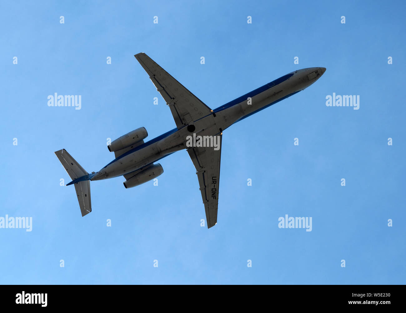 Embraer ERJ-145EU with registration UR-DNF airframe in the blue sky. Stock Photo