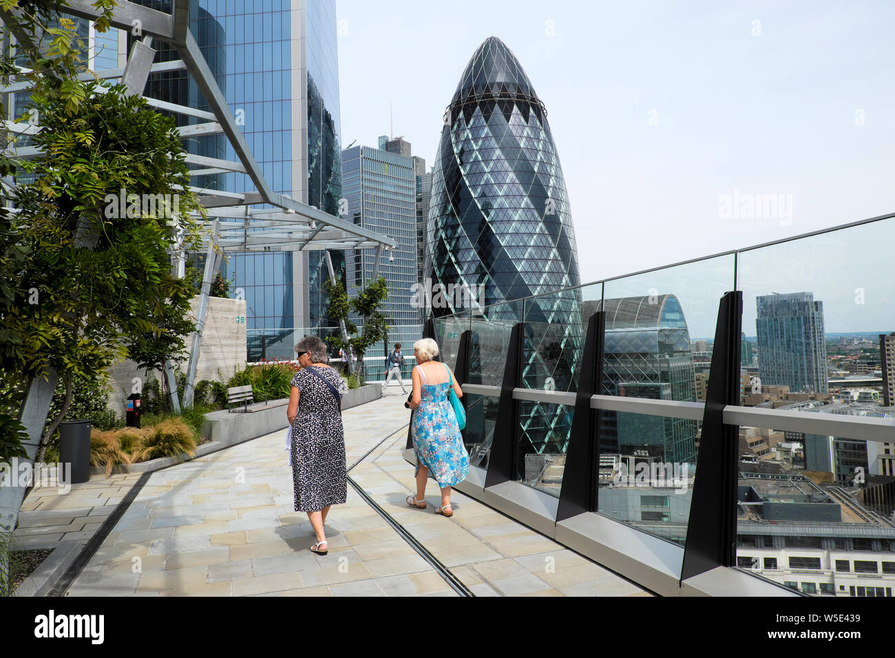 Visitors & view of gherkin building from the roofgarden at 120 Fenchurch Street City of London financial district in summer London UK  KATHY DEWITT Stock Photo