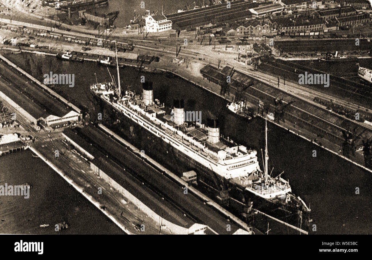 1930's Aerial view of  the Cunard liner Berengaria ( formerly SS Imperator) at Southampton Docks, UK - At the time of his completion in June 1913, it was the largest passenger ship in the world.-  Between 1934 and 1938 the vessel sailed the Southampton to New York  route via Cherbourg. During the years of US prohibition, Berengaria was used for discounted Prohibition-dodging cruises, which attracted the nickname 'Bargain-area' Stock Photo