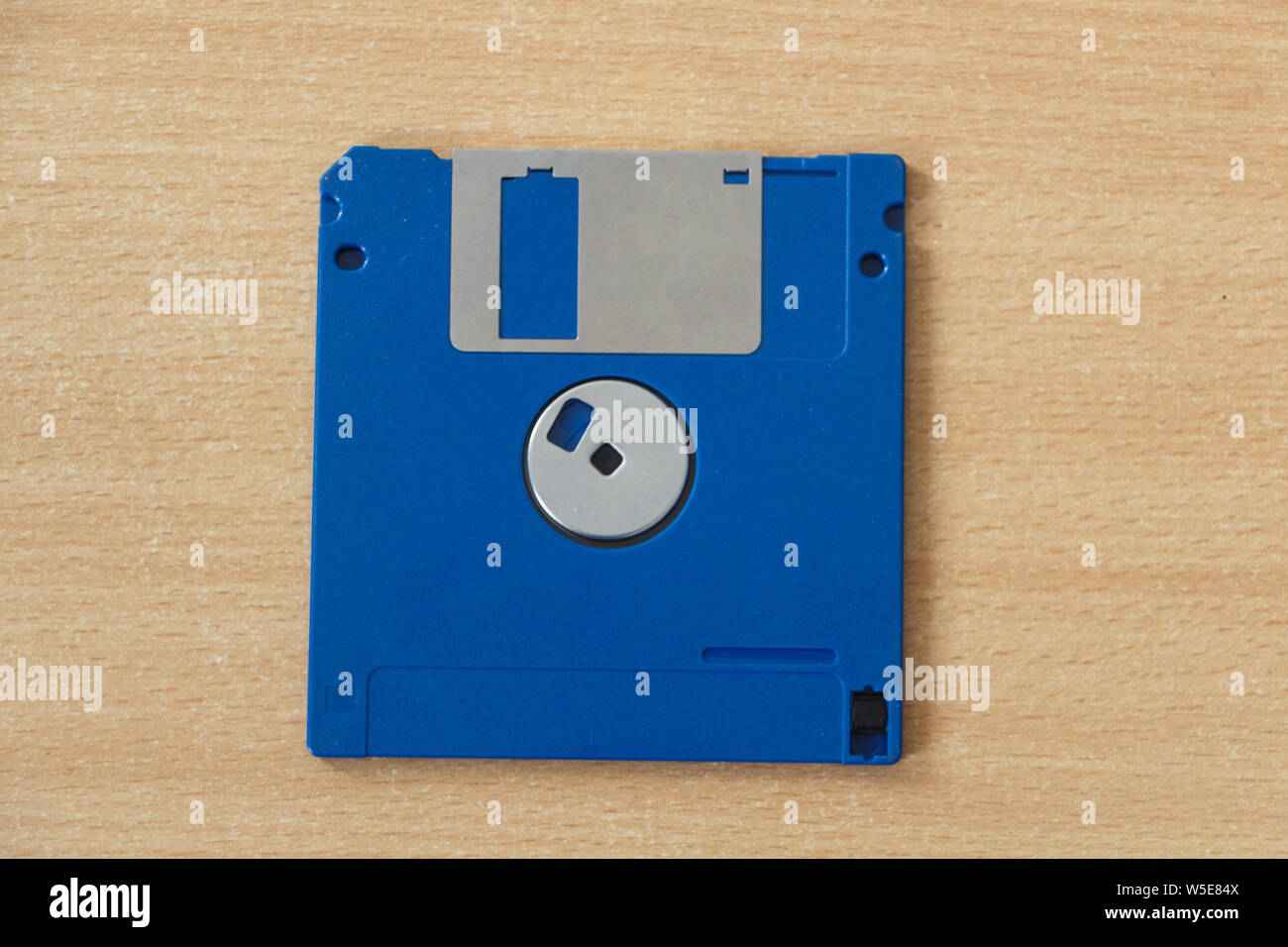 Blue obsolete computer diskette on wooden background Stock Photo