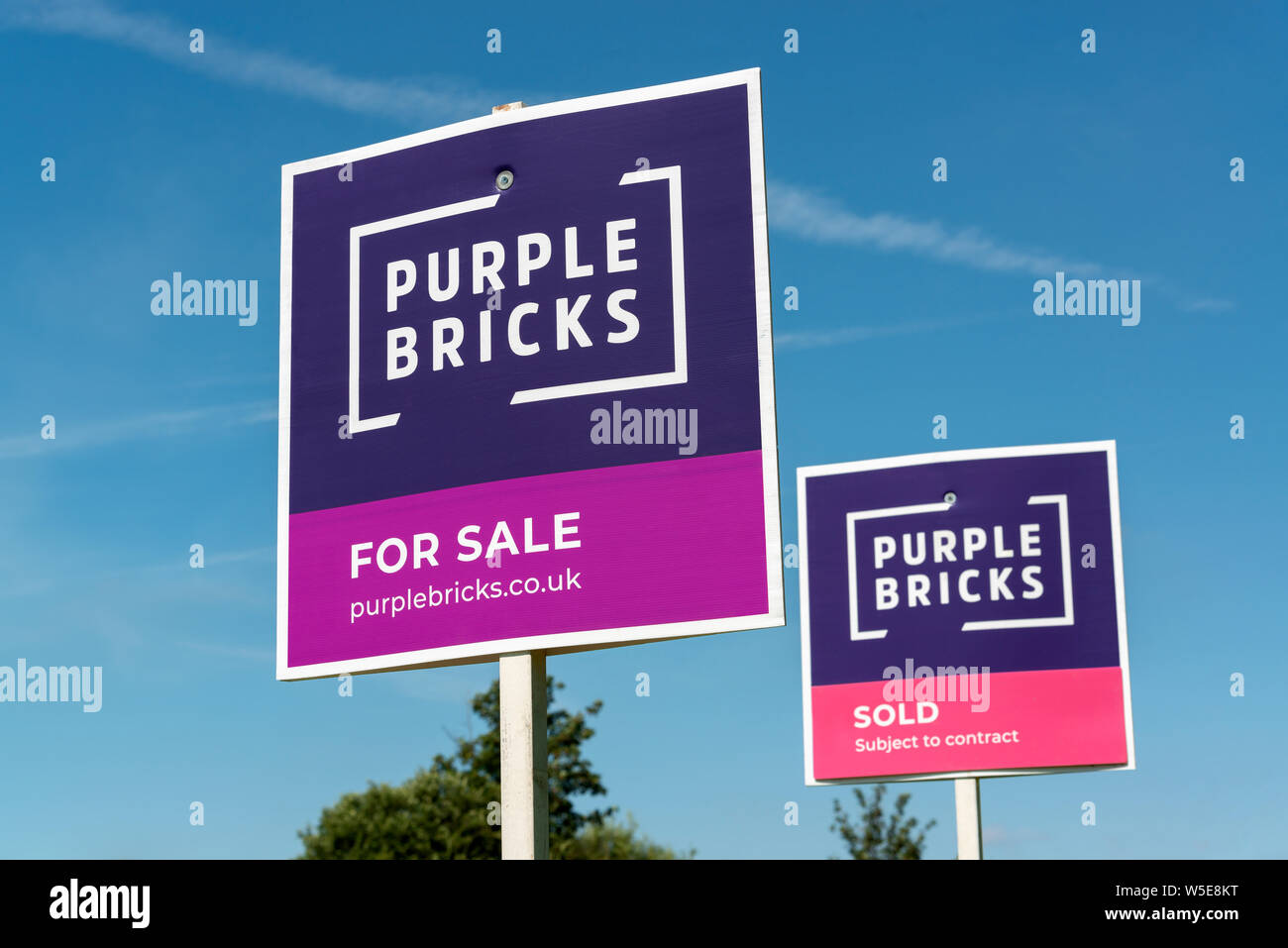 Two Purple Bricks signs side-by-side. One indicating a property 'for sale' and the other 'sold' (Editorial use only). Stock Photo
