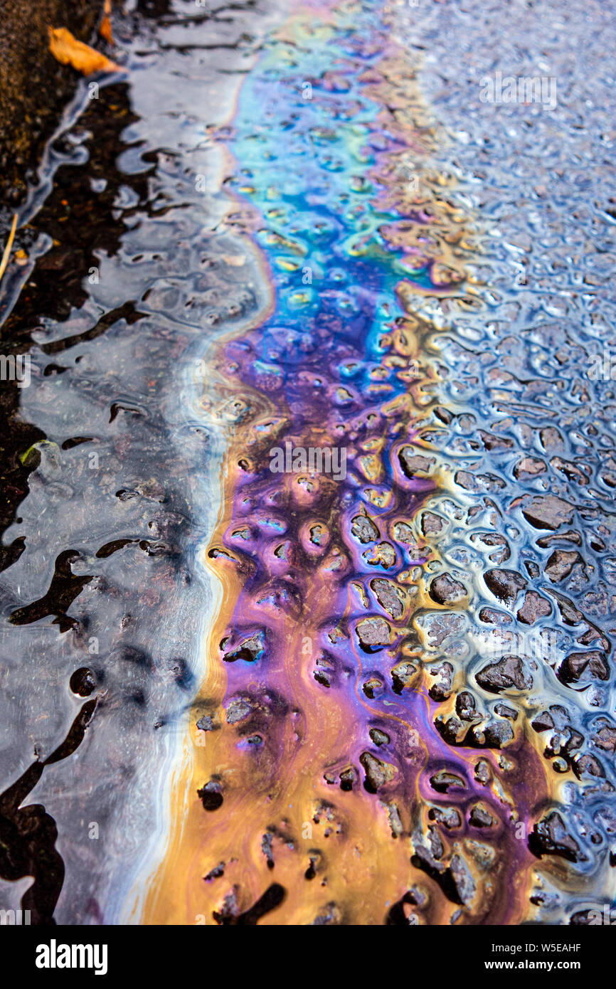 Spilt Petrol Gasoline Oil Running Down a Drain On a Road Gutter