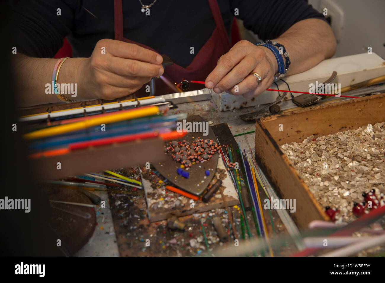 A skilled crafts woman on the Island of Murano in Venice , making pieces made from the famous Murano Glass. Stock Photo