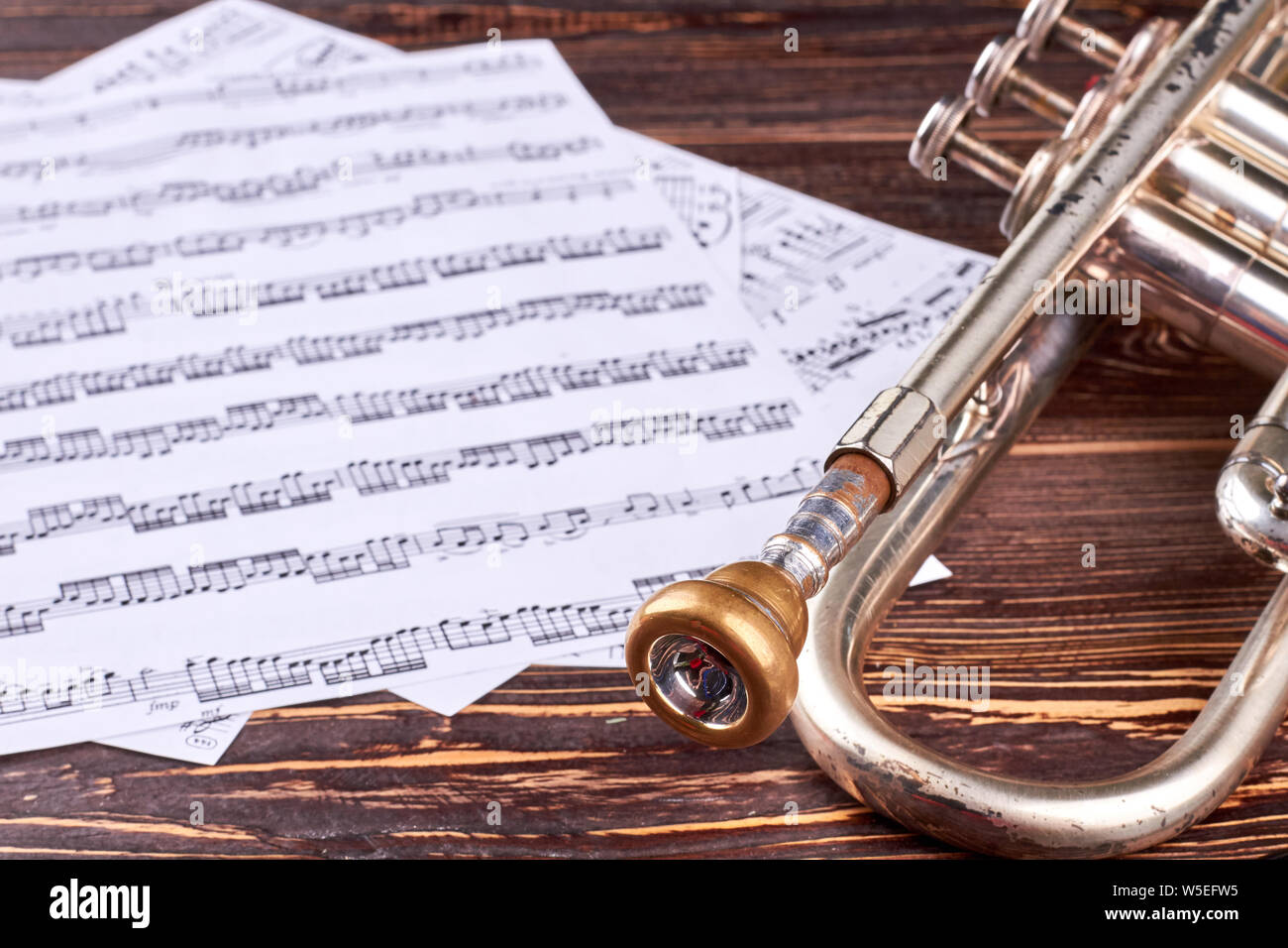 Old trumpet and music notes on wooden background Stock Photo - Alamy