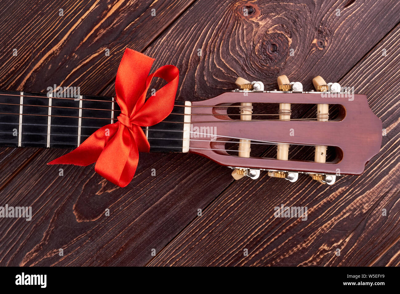 Acoustic guitar with red bow Stock Photo Alamy