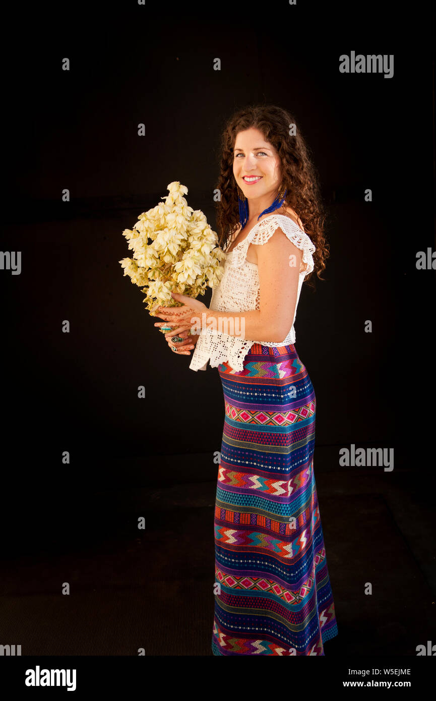 Beautiful woman with henna hands holding a giant Yucca bloom. Stock Photo
